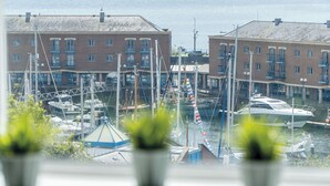 A marina with boats docked, buildings with balconies, and a clear sky. - Haven View - 2 Bedroom Apartment - Milford Haven (Milford Haven)