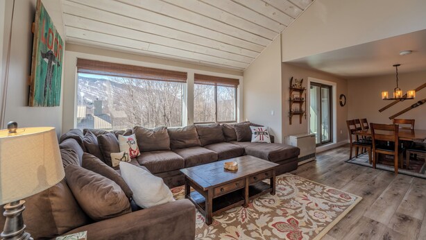 A spacious living area with a large sectional sofa, a wooden coffee table, and a patterned rug. - Loon Mountain View at Ravine (Lincoln)