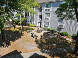 A residential building with a patio area featuring outdoor furniture and a barbecue grill. - Bright and Beachy 2BR/2BA Condo at the Arcadian Dunes 10-238, Bright and Beachy 2BR/2BA Condo at the (Horry County)