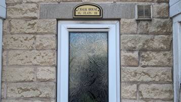 Un edificio de piedra con un letrero que dice "Chalk House 1G Flats 1H".