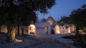 Un bâtiment traditionnel avec un toit en tuiles, des portes en arc de cercle et un chemin de pierre menant à l’entrée.