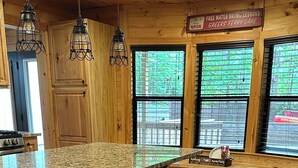 Una cocina con encimera de granito, taburetes de madera y un cartel anunciando clases gratuitas de esquí acuático.