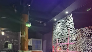 A bar area with a counter, stools, and a decorative wall. - Sky Beach Rooms (Montego Bay)