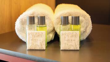 Two bottles of 'Natural Care' perfume and a white towel on a table.