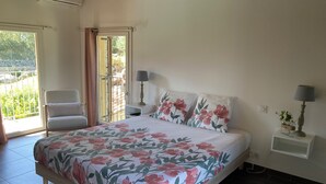 Une chambre à coucher avec un lit, une chaise, une table de chevet et une fenêtre avec des rideaux.
