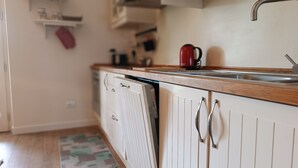 A kitchen with a wooden countertop, a sink, and a dishwasher. - Pepe Apartment: Peace and Relaxation in the Maremma countryside. (Toscana)