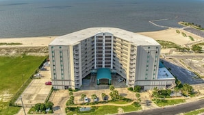 A large, multi-story hotel with a central atrium and a parking lot in front.