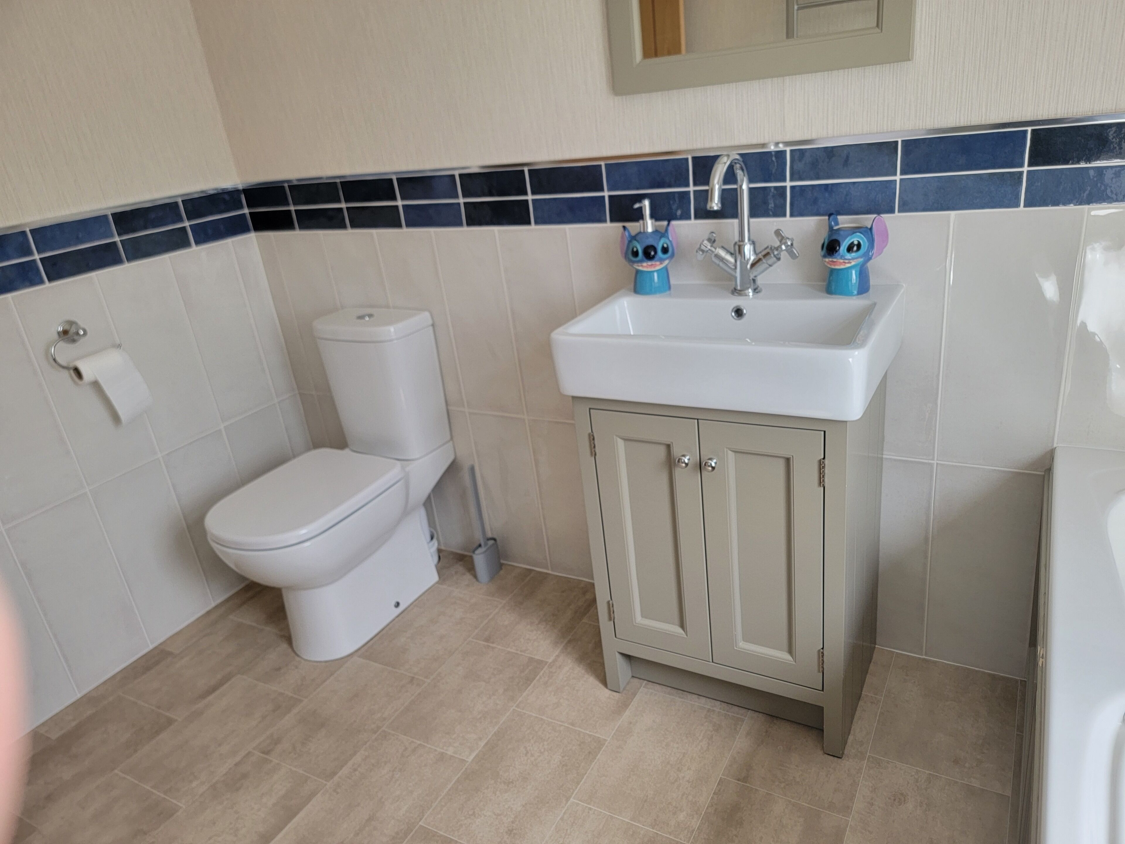 A bathroom with a toilet, sink, and cabinet.