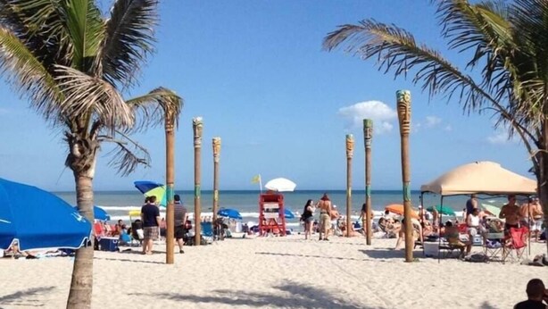 A beach with palm trees, umbrellas, and people. - 2 Homes Together|Sleeps 16|Walk 2 Beach|Firepit (Cocoa Beach)