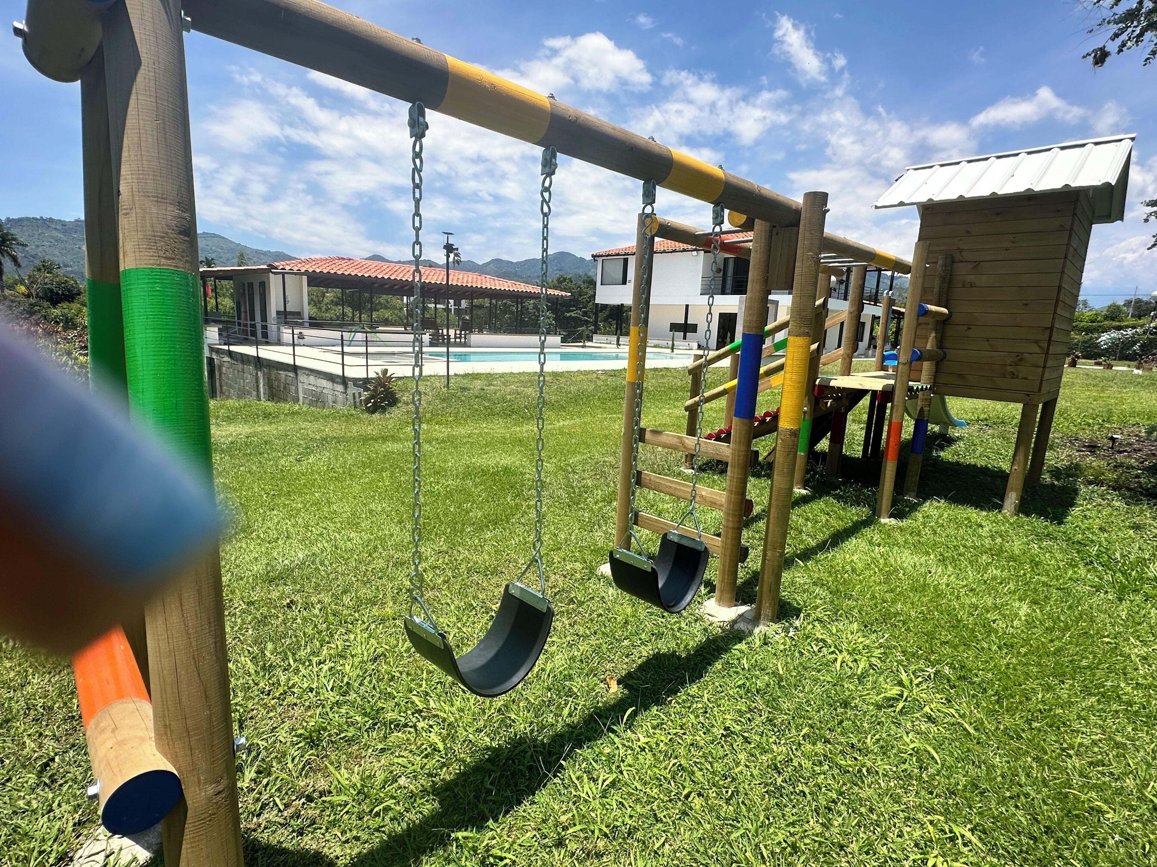 Un parque infantil con columpios y una estructura para escalar.