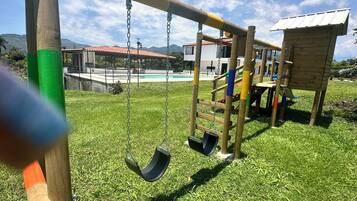 Un parque infantil con columpios y una estructura para escalar.