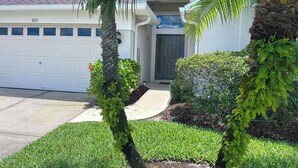 A residential house with a garage, a front door, and a well-maintained lawn. - EP1051SEL - Private Vacation Pool Home Near Disney (Kissimmee)