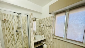 A bathroom with a shower, a sink, and a window. - La trinacria (Syracuse)