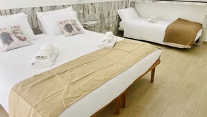 A hotel room with a large bed, a bench, and a massage table. - La trinacria (Syracuse)