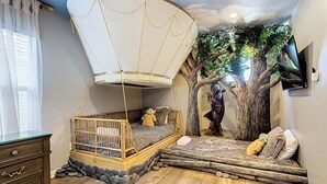 A room with a canopy bed, a tree mural, and a television on the wall. - WH7820BS - 5 bedrooms - 5 baths - Nemo and Star Wars  - Big Pool - Theater Room (Kissimmee)