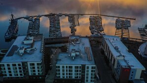 A high-rise building with multiple floors, a rooftop parking area, and a helipad. - Marina Square Suites (Bremerton)