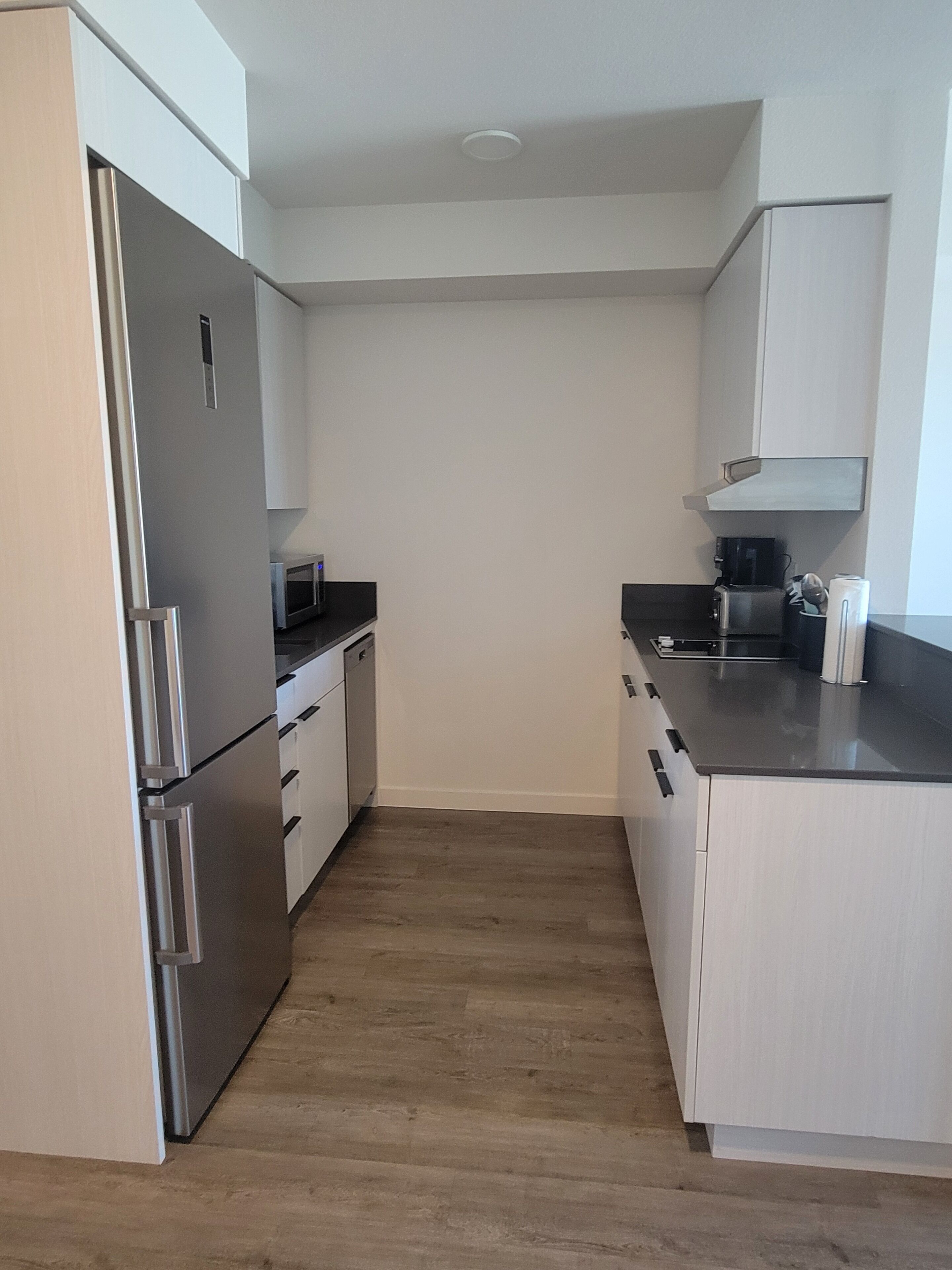 A compact kitchen with a refrigerator, microwave, and coffee maker.