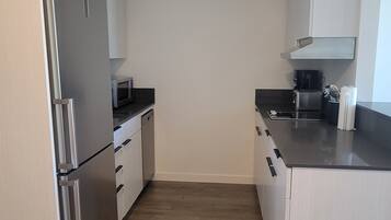 A compact kitchen with a refrigerator, microwave, and coffee maker.