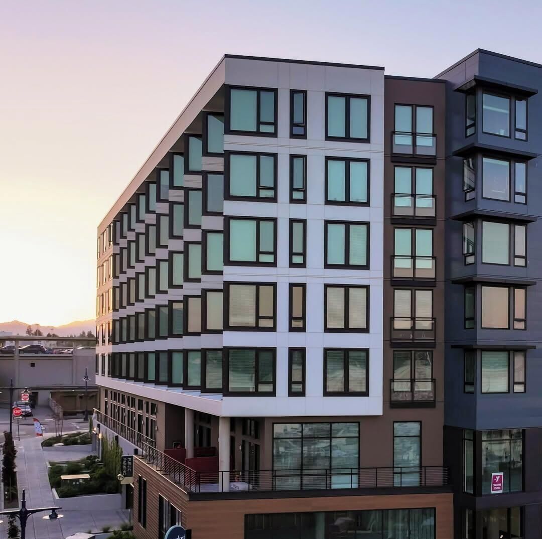 A multi-story building with a modern architectural design, featuring a mix of window patterns and balconies.