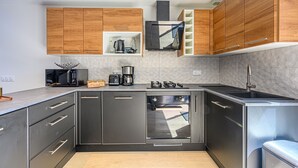 Una cocina moderna con armarios de madera, horno integrado, estufa y lavaplatos.