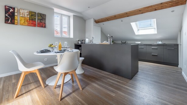 A modern kitchen with a central island, white chairs, and a dining table. - Le Jarente - Appt pour 2 centre de Lyon (Lyon)