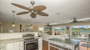A modern kitchen with a built-in oven, a dining area with a table and chairs, and a large sliding glass door leading to a balcony with a view of the water. - Beautiful 6 bedroom lake house. Pontoon available for rent (Union)