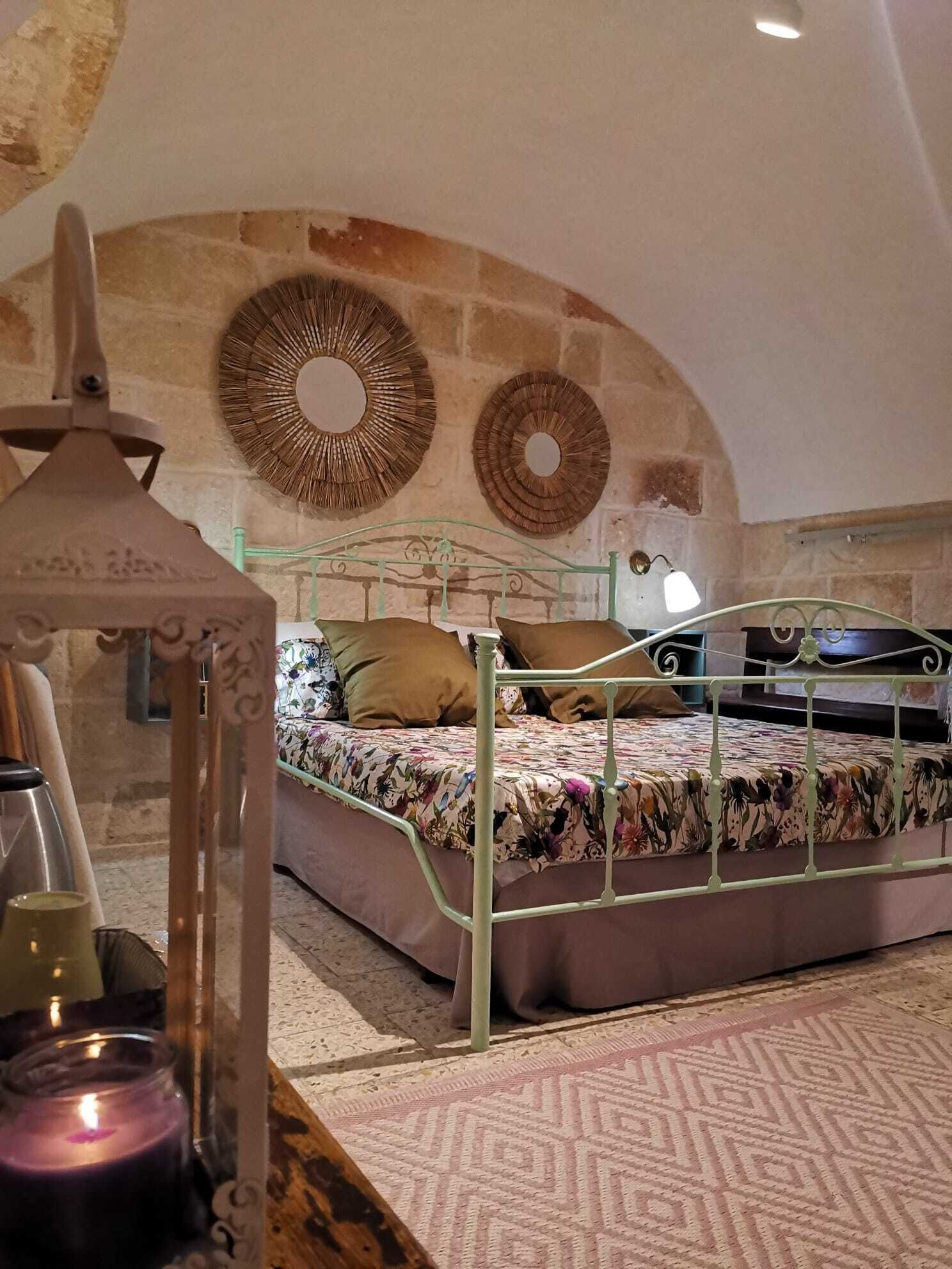 Une chambre à coucher avec un lit, une lampe et un miroir fixé au mur.