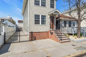 A two-story house with a brick foundation and a front porch.
