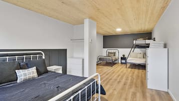 A modern bedroom with a bunk bed, a bedside table, and a wardrobe.