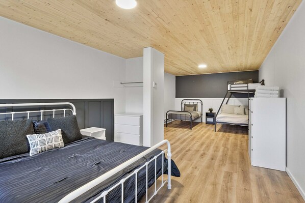 Quarto moderno com beliche, mesa de cabeceira e guarda-roupa.