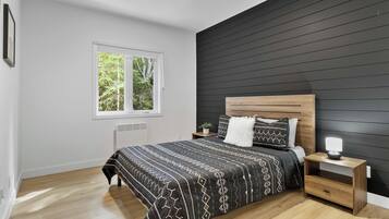Une chambre à coucher moderne avec un lit, une table de chevet et une fenêtre.