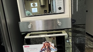A kitchen with a microwave, oven, and a digital clock displaying 8:08. - Relaxation (Aswan)