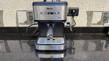 A Mienza coffee machine with a 20-bar pump, connected to a power outlet on a black countertop.