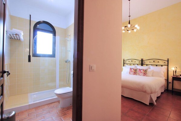 Un baño con ducha, inodoro y ventana.