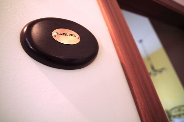 A door handle with a plaque that reads "HOJIBLANCA".