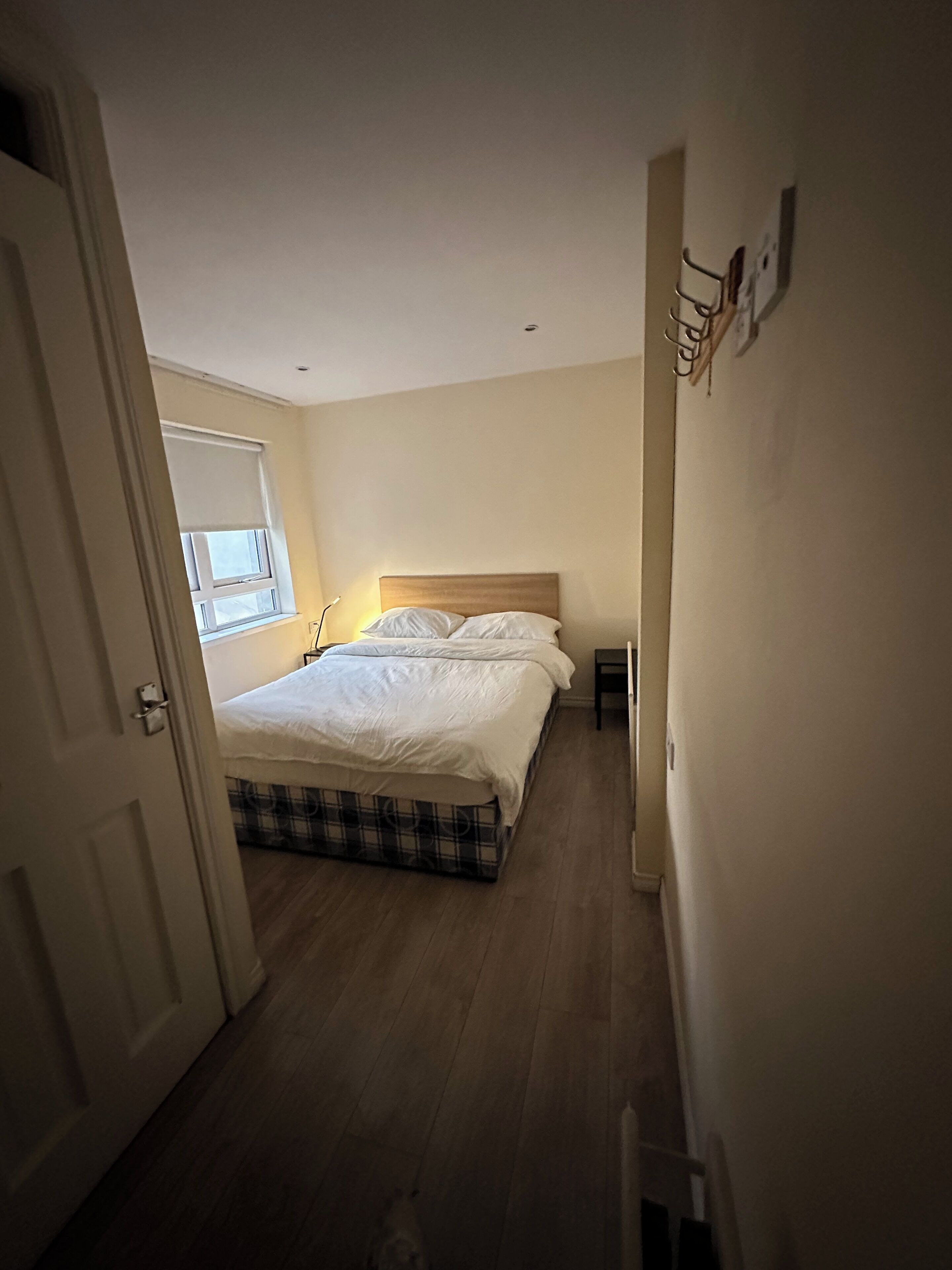 Un dormitorio con cama, ventana y puerta.