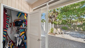 An open door to a room with a view of a backyard, a ladder, cleaning supplies, and a striped blanket. - Updated, Adorable, Close to Beach and Shops (Longboat Key)