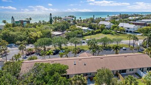 A coastal residential area with houses, palm trees, and a view of the ocean. - Updated, Adorable, Close to Beach and Shops (Longboat Key)