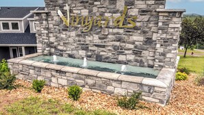 A stone wall with the word "Vinyards" and a water feature.