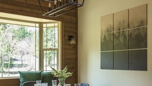 Een eetgedeelte met een houten tafel, stoelen en een hanglamp.