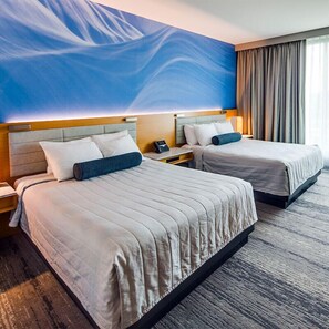 A hotel room with two beds, a large abstract mural on the wall, and a view of the outdoors through the window. - Treasure Island Resort & Casino (Welch)