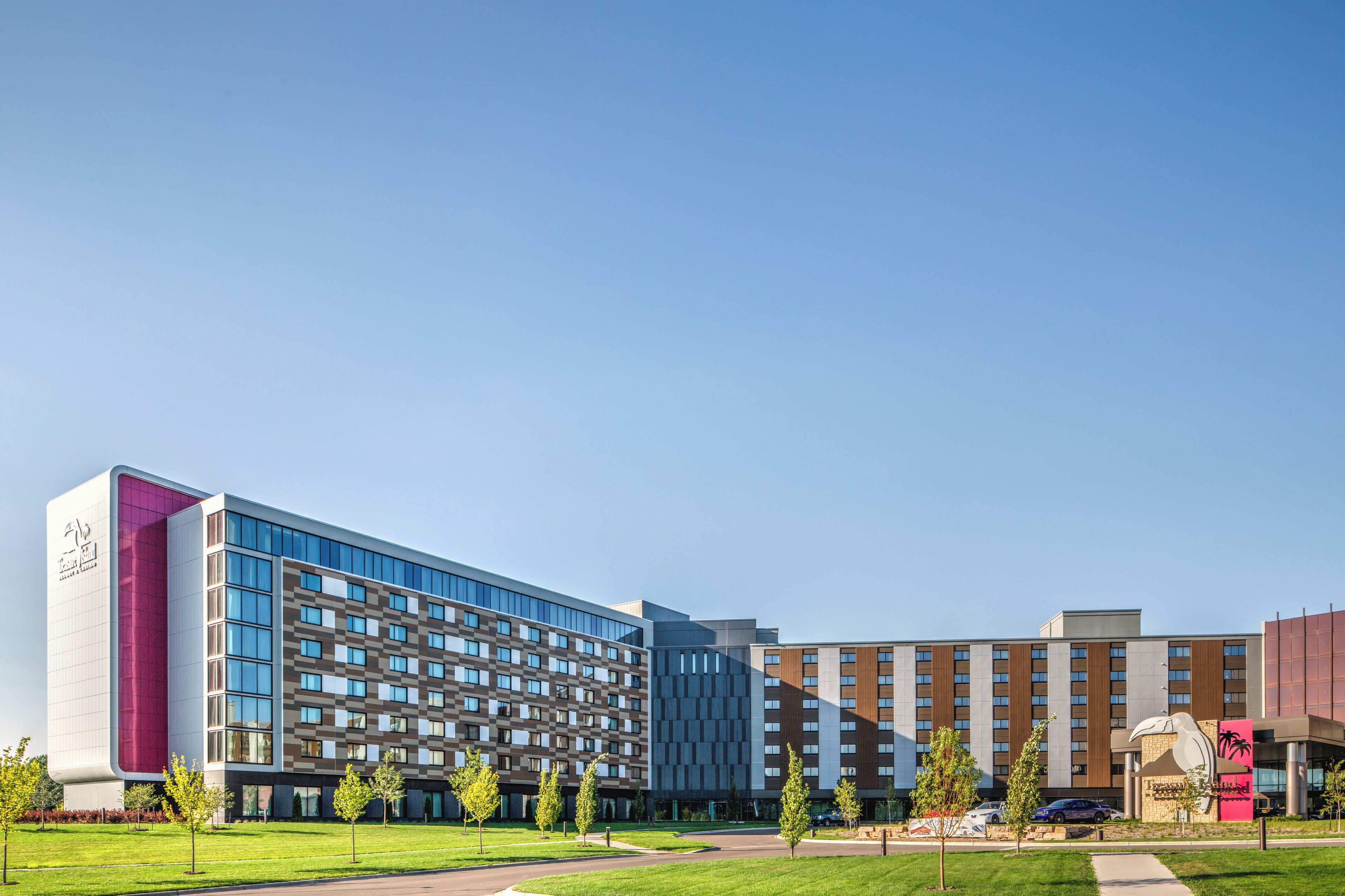 Un hotel moderno con varias construcciones, un patio central y una gran escultura.