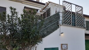 A building with a green door, a staircase with a metal railing, and a sign that reads "Parchio Resort".
