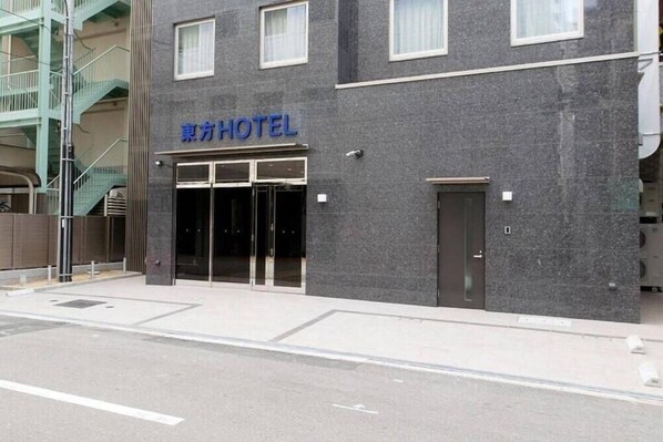 A modern hotel building with a sign reading "HOTEL" in blue letters. - Toho Hotel Namba Motomachi (Osaka)