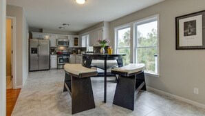 A modern kitchen with white cabinets, stainless steel appliances, and a central island with seating. - “Crescent Moon” - 5BR – established, top rated, dog friendly, 5 min walk to beach! (Folly Beach)