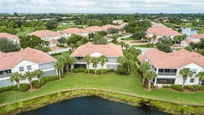 An aerial view of a residential area with houses, a body of water, and greenery. - Beautiful Relaxing condo with a Lake/Golf Course view 8 miles from beach! (Fort Myers)