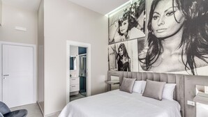 Een moderne slaapkamer met een groot bed, een kledingkast en een spiegel.