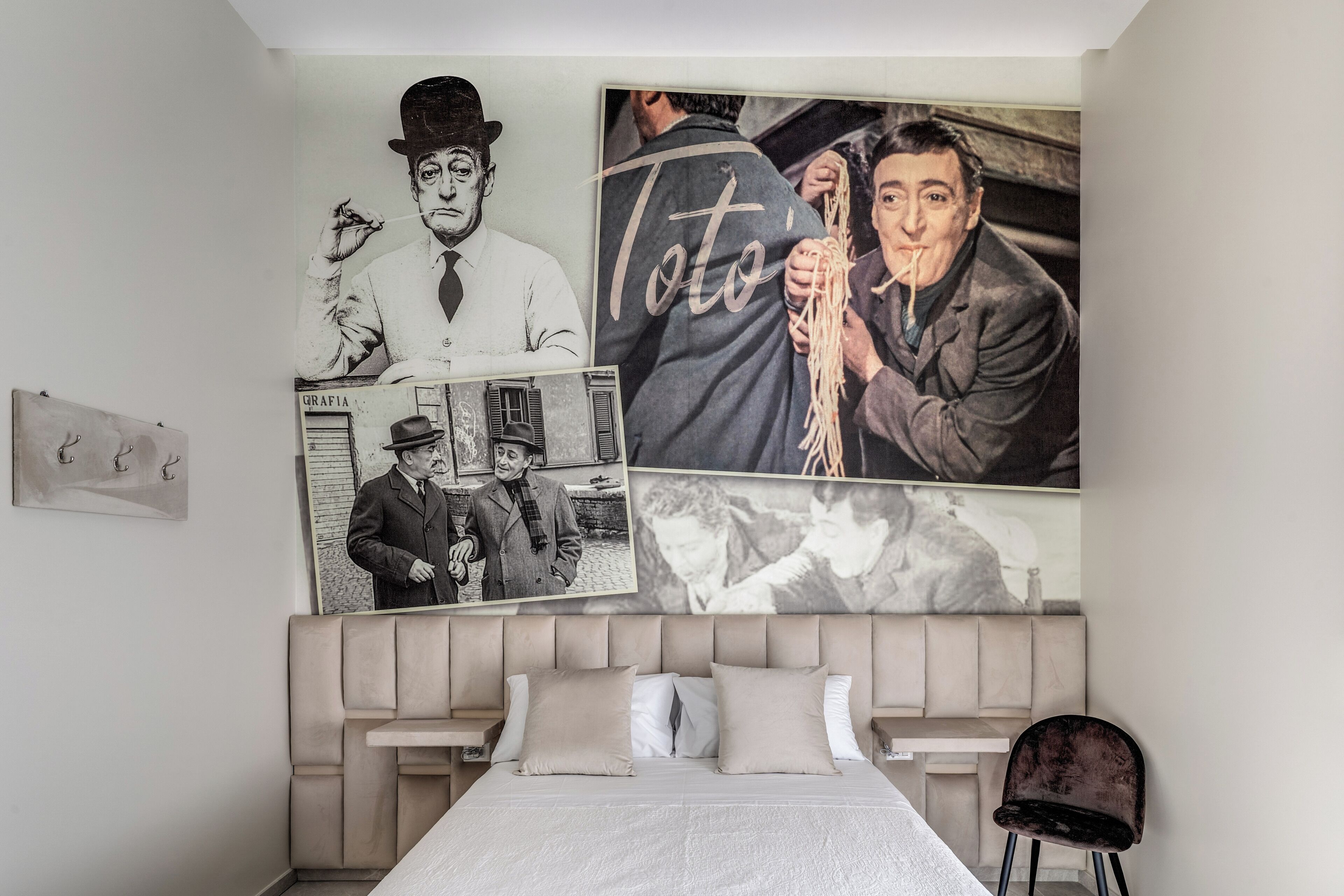 A bedroom with a bed, a headboard, and a wall with multiple framed pictures.