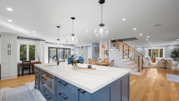 A modern kitchen with a large island, wooden flooring, and pendant lighting. - Family getaway.Commuter's Dream.Weddings&Events.Content House.Luxury Smart Home (Larchmont)