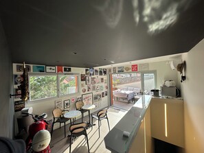 Un interno moderno con un'area pranzo, una moto rossa e un'ampia finestra con vista.